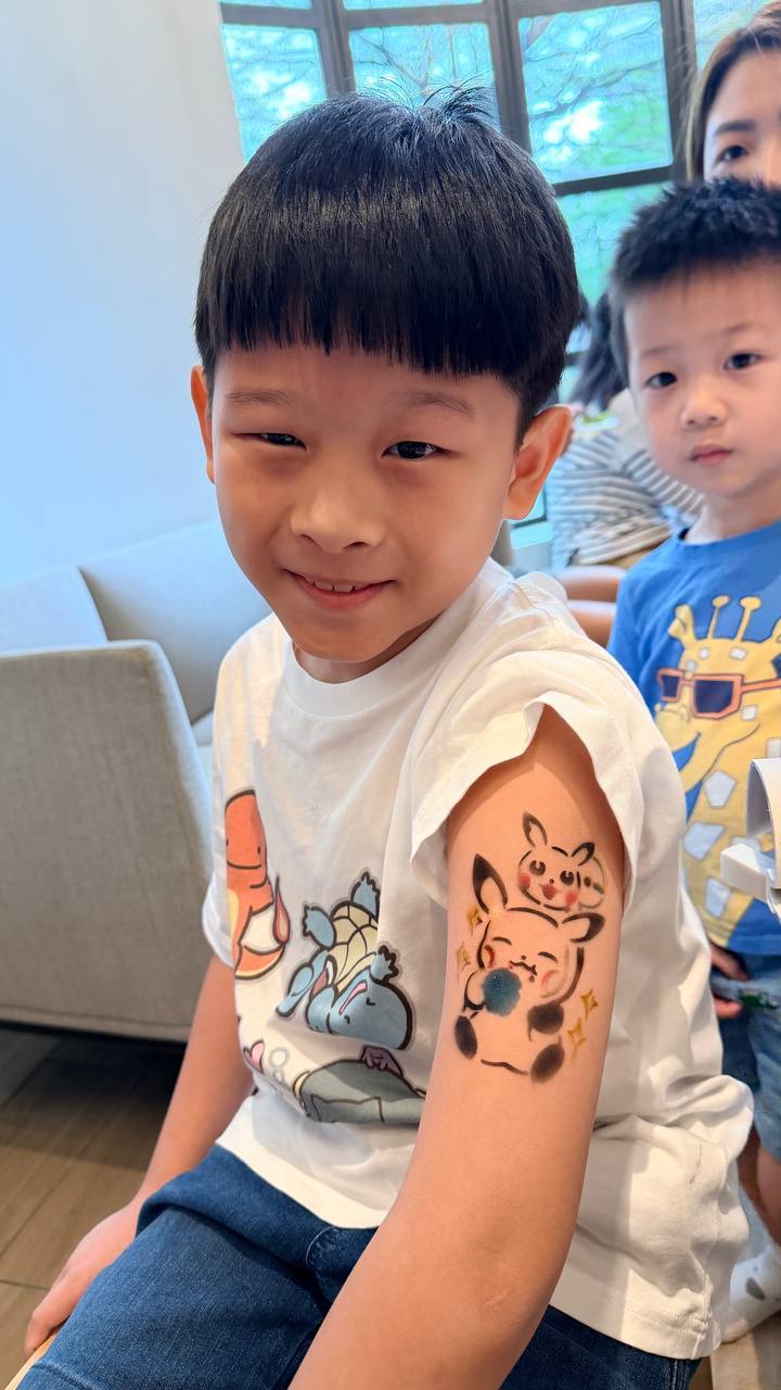 Kid showing Pikachu airbrush tattoo