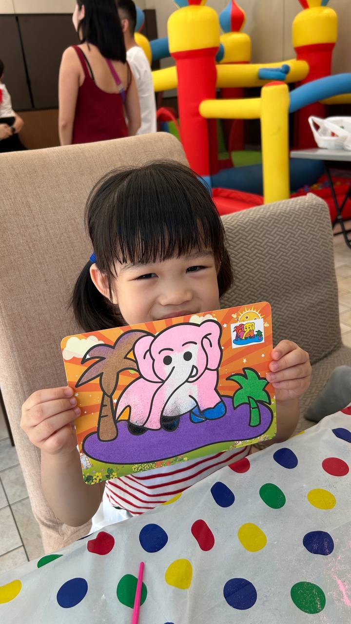 Girl proudly showing elephant sand art