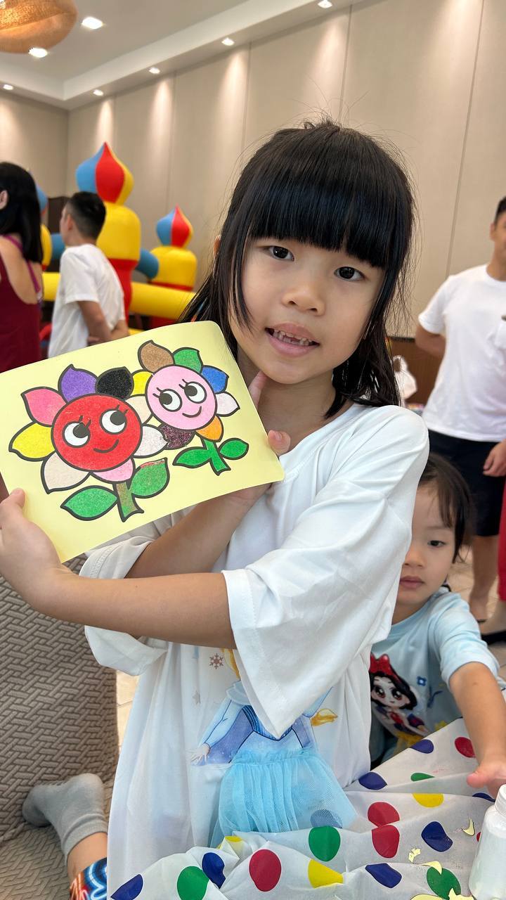 Girl showing flower sand art creation
